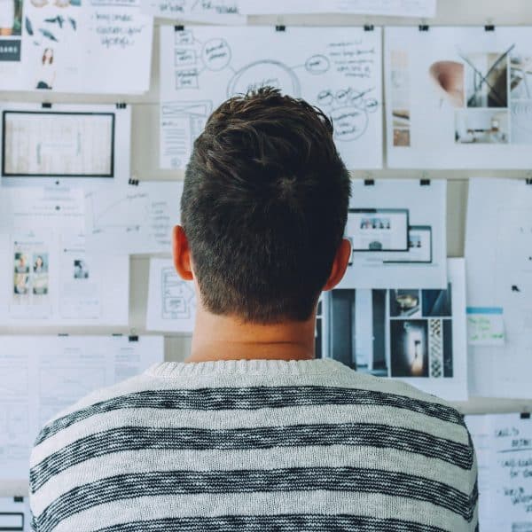 a man indoors looking at a whiteboard